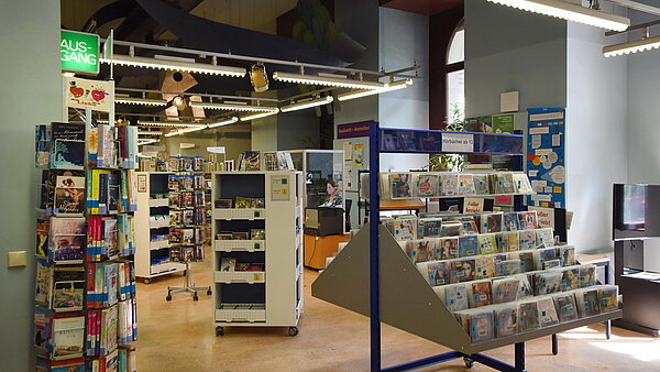 Hier ist der zweite Raum in der Kinder- und Jugendbibliothek abgebildet. Hier befinden sich neben Bücherregalen auch Tröge mit Hör- und Musik-CDs 