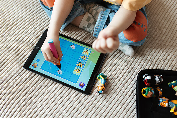 Ein Kind spielt ein Edurino-Lernspiel auf einem Tablet. 